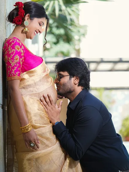 There is so much joy in anticipation. This is a close, intimate moment from a maternity photoshoot, capturing the partner's connection to the baby bump in a way that feels warm and genuine.