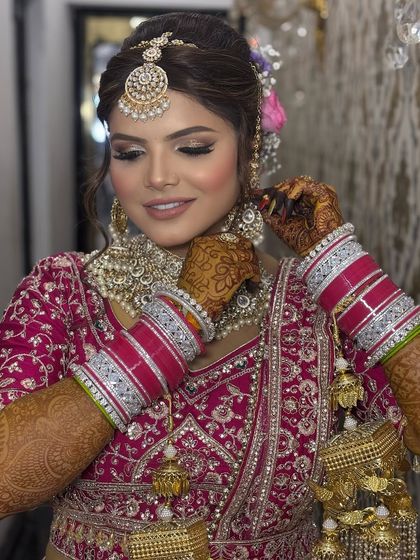 A candid moment of the bride adjusting her earring. This shot shows the makeup in a natural, unposed way and highlights her stunning jewelry.