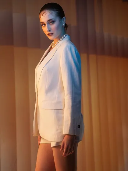 A sophisticated and minimalist look. I used a combination of warm and cool lighting against a simple, textured background to sculpt the lines of the white suit and create a chic, modern portrait.
