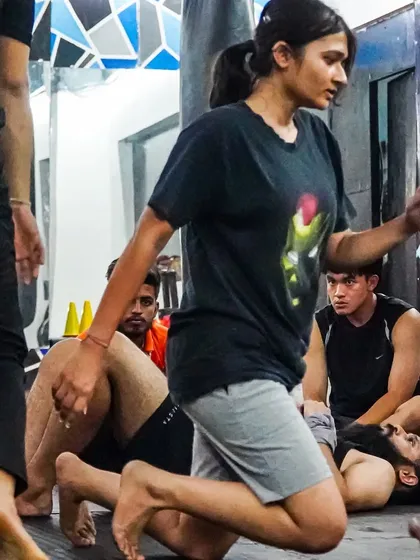 A member navigates a ground-based mobility drill during our group warm-up. These exercises are crucial for building the agility and coordination needed for combat sports.