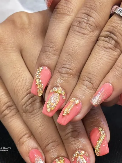 A detailed close-up of the jewel-encrusted nails, showing the different shapes of the gold charms and the sparkle of the surrounding crystals.
