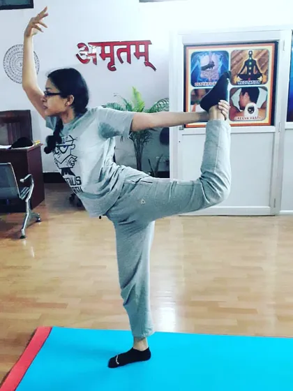 A student holds Natarajasana (Lord of the Dance Pose) with grace. This pose is a beautiful expression of balance, strength, and flexibility, requiring deep focus and an open heart.
