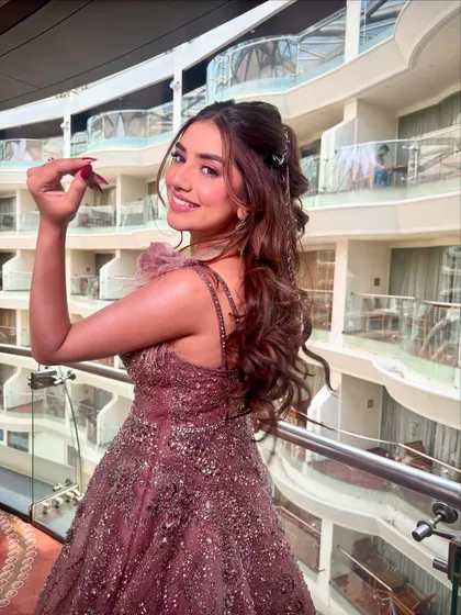 This angle shows off the bouncy, textured curls and the half-up braid with diamond tassels. The soft and glowy makeup complements the whimsical hairstyle, creating a look that is both elegant and fun.