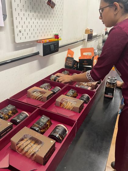 Here's a glimpse of my team member assembling our Diwali hampers. Each box is carefully packed by hand to ensure a beautiful presentation and safe delivery of all the gourmet goodies inside.