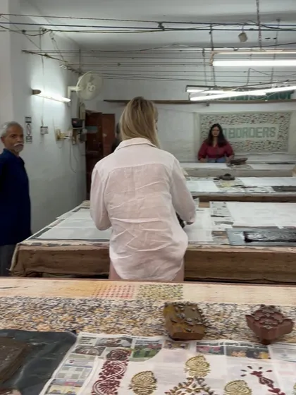 A participant fully immersed in the printing process during a workshop. Our long printing tables provide ample space for everyone to work, experiment, and share in the collective energy of creation.
