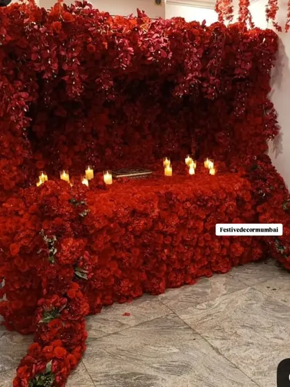 An all-red Ganpati mandap that exudes passion and devotion. The setup is made entirely of red flowers and is illuminated by the soft glow of candles, creating an intimate and powerful ambiance.