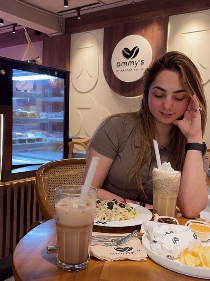 A candid shot from a coffee date, wearing a simple brown t-shirt. This is my real, everyday style.