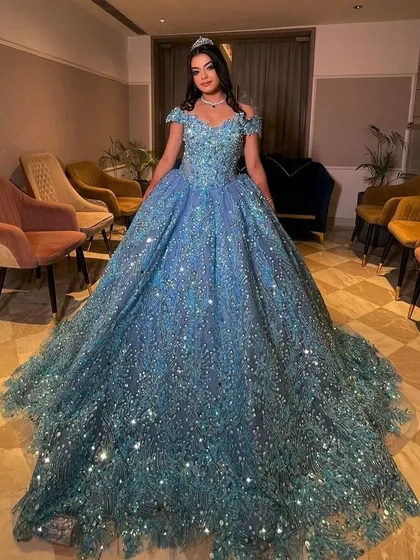 Here is one of my clients looking like a true princess in a fully embellished ice-blue ball gown. This rental gown is perfect for an engagement or reception, featuring off-shoulder sleeves and a voluminous skirt that sparkles with every movement.