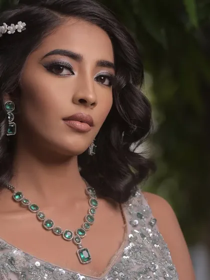 A perfect cocktail party look. The soft waves, winged liner, and emerald jewelry create a sophisticated and modern vibe.