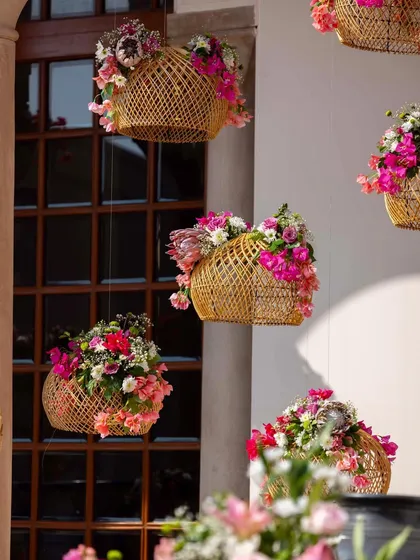 Hanging wicker baskets overflowing with bougainvillea and other pink and white blooms. This was a simple yet highly effective way to add floral charm and a touch of boho chic to the space.