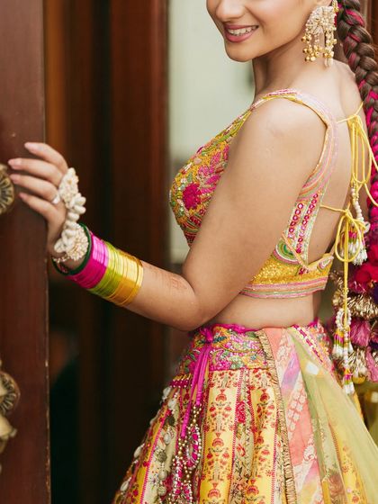 A close-up on the details. The colorful bangles, the floral hand jewelry, and the peek of her pleated braid all come together beautifully.