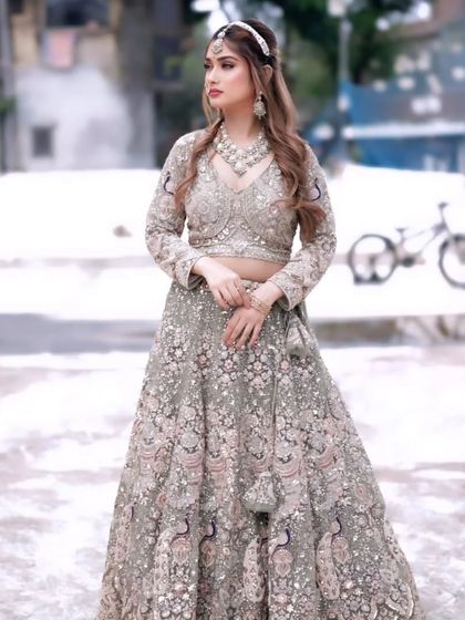 A full-length shot of our sage green lehenga with heavy silver and pink embroidery. This is a very popular color and a great rental for a modern bride or bridesmaid.