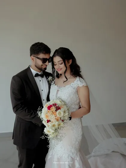 A modern and cool portrait of the bride and groom, his sunglasses adding a touch of contemporary style to their classic wedding attire.