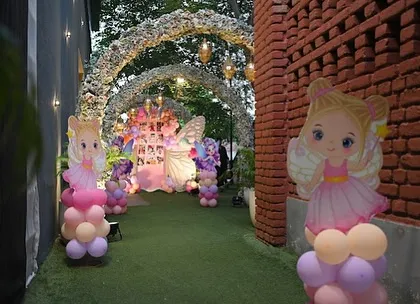 A view down the garden path, lined with fairy cutouts and balloon columns, leading to the main butterfly-themed backdrop. We love creating an immersive journey for guests.
