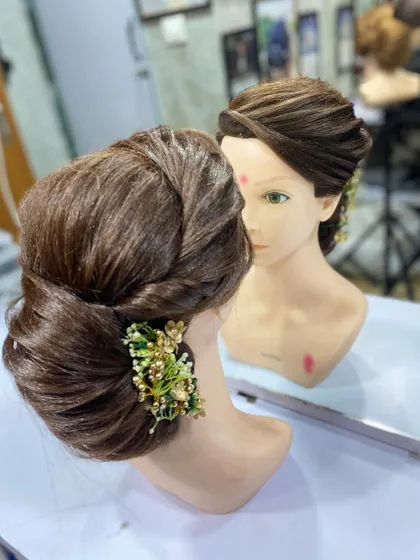 A front facing view of the student's work, showing how the updo is reflected in the mirror.