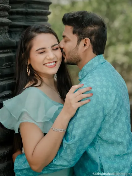 A sweet and candid moment of the groom kissing the bride's cheek. Her joyful, smiling reaction is what makes this photo so special and full of genuine emotion.