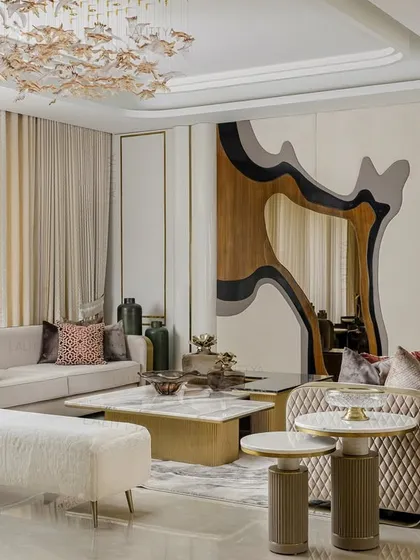 A wider perspective of the living corner, showing how the custom quilted sofas and unique wall feature create a sophisticated and artful environment. The overhead chandelier adds a final touch of glamour.
