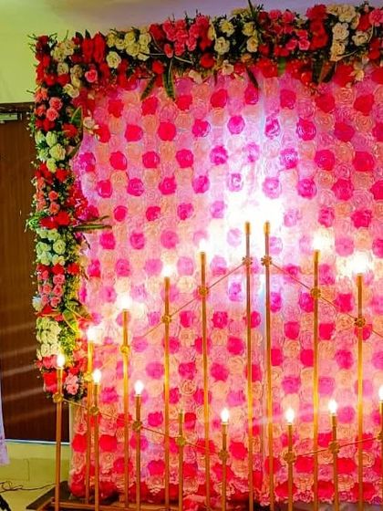This engagement entrance decor doubles as a beautiful photo backdrop. It features a wall of pink floral panels, a candle wall, and a personalized welcome sign for the couple.