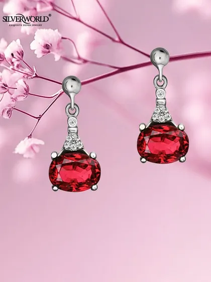 Ignite your look with these passionate red drop earrings. The oval-cut red stone is set in a four-prong 92.5 silver setting, accented with small zirconia for extra sparkle.