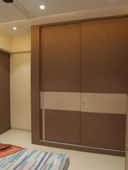 The two-tone sliding wardrobe provides ample storage while maintaining a sleek look.