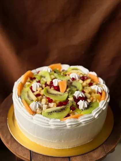 Another angle of the mixed fruit cake, showing the generous layer of fresh cream and fruit.