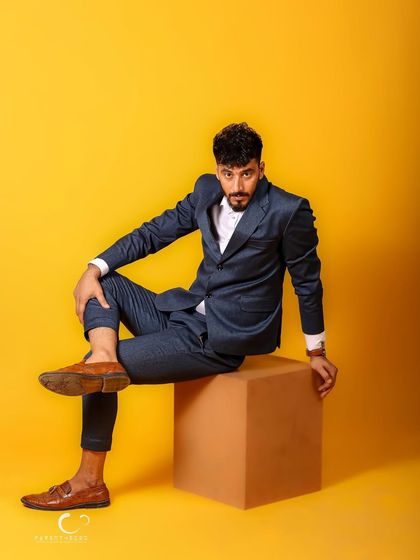 A casual, cross-legged pose that feels effortlessly cool. This portrait shows that style is about attitude, not just the clothes you wear.