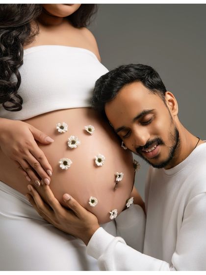 Listening for a heartbeat. This intimate and sweet photo captures the father-to-be listening to the baby bump, a classic pose filled with love and connection.