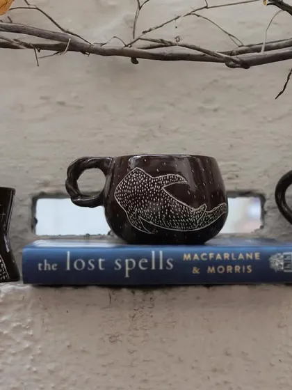 'The Lost Marines' is a set of three mugs I created using the Mishima technique on black clay. I carved the designs and inlaid them with white slip, creating a stark, beautiful contrast that I love.