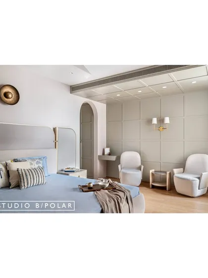 The parents' bedroom at Sunlit Serenity has an earthy and light aesthetic. The feature wall has contemporary moldings that extend onto the ceiling, adding architectural interest.