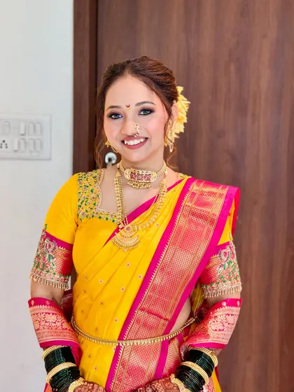 A full-length view of the bride in her stunning yellow Nauvari saree, expertly draped to create a classic silhouette.