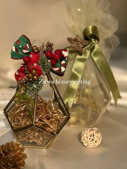 For Christmas, even small gifts can be luxurious. This image shows a geometric terrarium and a treat-filled potli, both decorated with festive Christmas bows.