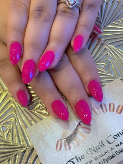 A duplicate of image 83, showcasing a vibrant set of almond-shaped nails in a deep, glossy magenta color.