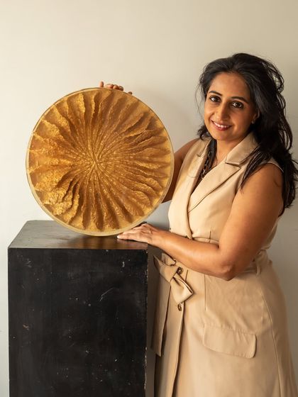 A portrait with "The Golden Flower." This piece, crafted from upcycled paper and encased in resin, blooms with a new voice: fresh, radiant, and versatile.