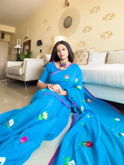 A saree calling! This bright blue mul cotton saree with colorful hand embroidery is proof that you don't need a special occasion to wear a saree. It's perfect for any day.