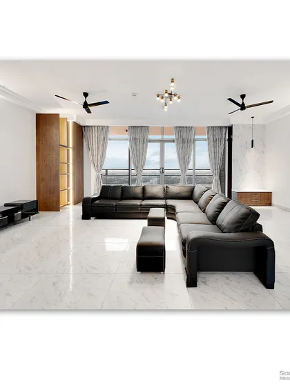 A spacious living room with a large black leather sectional sofa, set against a backdrop of expansive windows. The minimalist design and clean white marble floors create a sleek and modern aesthetic.