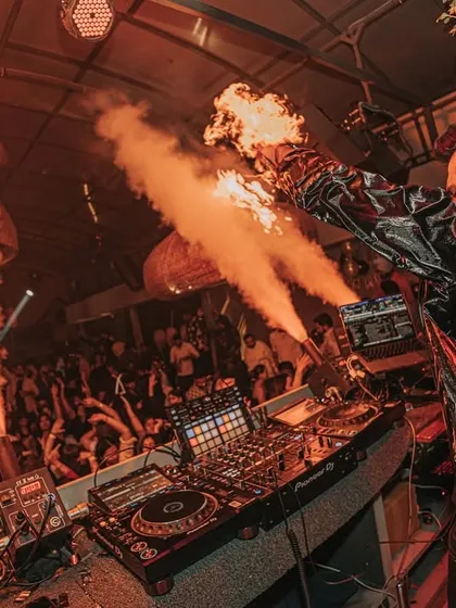 A side view of the action, with fire effects framing the DJ console at De'orra.