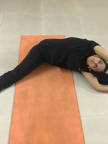 A student practices Parshva Upavistha Konasana, a seated side straddle pose. This asana stretches the side body, hamstrings, and inner thighs.