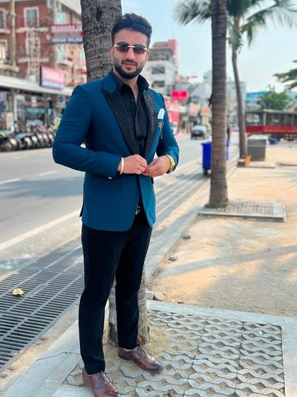 Our client confidently wears his custom teal blazer. The sharp tailoring and unique color make it a modern and fashionable choice.