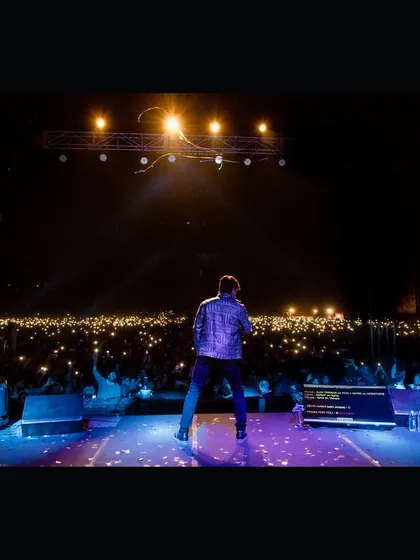 A powerful shot of singer Shaan facing a sea of lights from the audience at IIT Dhanbad. We create moments that connect artists with their fans for an unforgettable concert experience.
