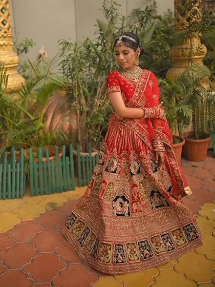 A full view of this bride's stunning red lehenga with intricate 'doli' embroidery. My goal was to create a soft, subtle makeup look that allowed the magnificent outfit and her natural beauty to shine.