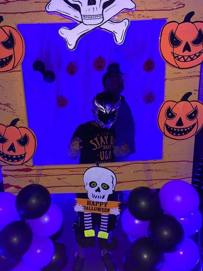 Another guest enjoying the Halloween photo booth. The dark blue lighting adds to the spooky ambiance, making it a fun and interactive part of the party.