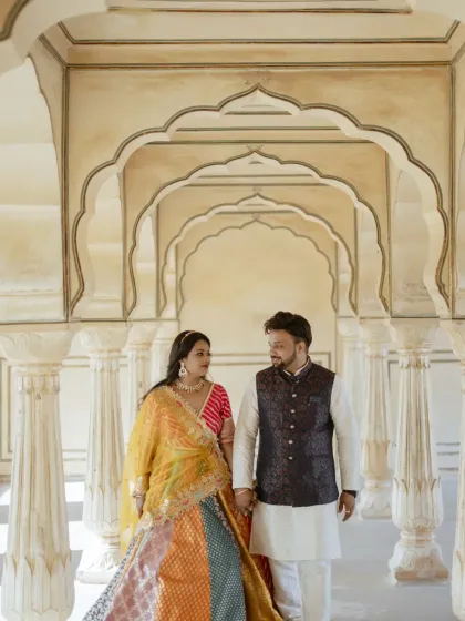 A classic walking shot through a palace corridor. The couple's coordinated traditional outfits and the symmetrical architecture come together to create a picture of pure elegance for their pre-wedding album.
