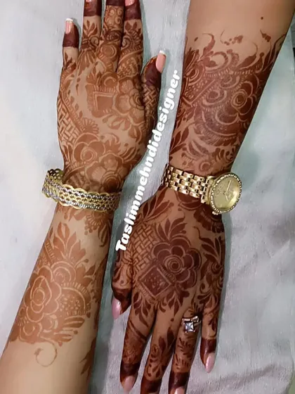 A beautiful floral design for a client, showing the fresh henna stain. The pattern flows from the arm down to the hand, accessorized perfectly with a watch and bracelet.