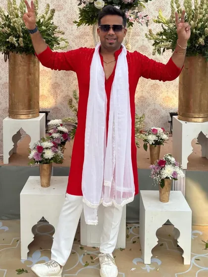 Victory signs for a successful event. This full-length shot shows how a simple, well-fitted traditional outfit can make a strong impression.
