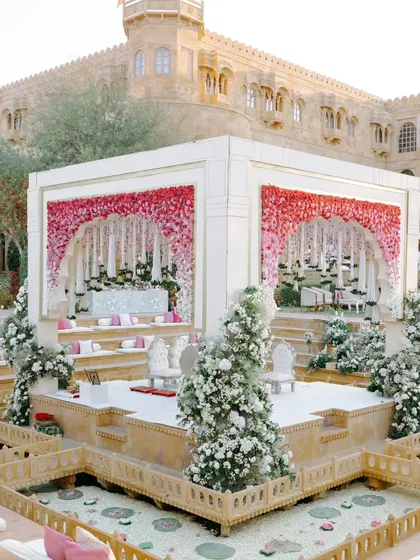 A fairytale mandap at Suryagarh, adorned with a gradient of pink and white florals. The design creates a beautiful contrast with the heritage architecture, blending romance and royalty.