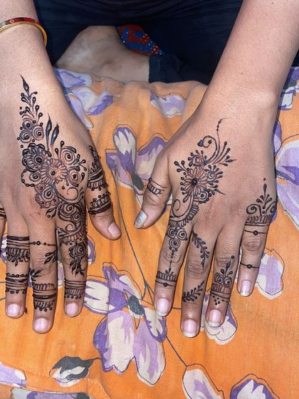 A simple and elegant sider mehndi, with delicate patterns on the fingers and back of the hand.