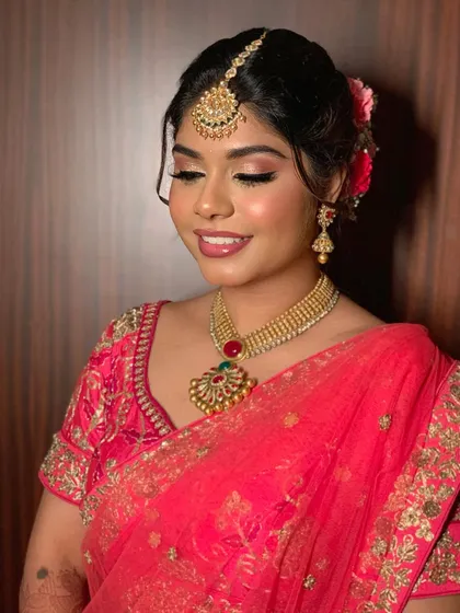 Simran gleaming in her bridal glory. This look for her ceremony features a bright pink saree with soft, glowing makeup and a glossy pink lip.