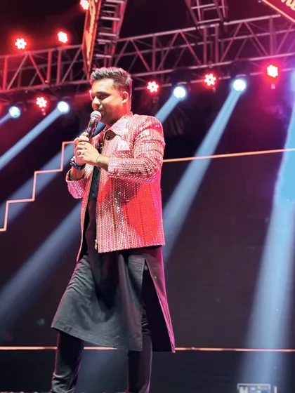 A candid moment on stage, speaking to the audience. The lighting and my posture reflect the professional and polished performance I deliver.