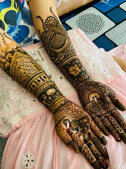 This design combines architectural elements with classic motifs like the peacock and lotus. The result is a unique and sophisticated full-arm bridal mehndi.
