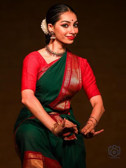 A classic pose from a Bharatanatyam recital, filled with expression. The slight smile and hand gesture combine to tell a part of the story.